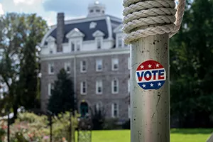 "Vote" sticker on a pole in front of Parrish Hall